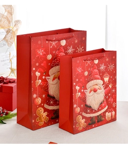 Detail of large and small red Christmas gift bags with Santa Claus and gingerbread prints