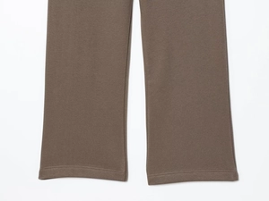 Detail of reinforced double stitching on brown trousers hem with fine knit texture