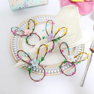 Detailed view of colorful rabbit ear flower napkin rings on elegant dinner plates