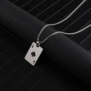Macro shot of silver titanium ace of spades pendant on a box chain over a textured stand