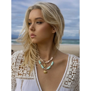 Detail of layered gold starfish and shell pendant necklace with colorful beads