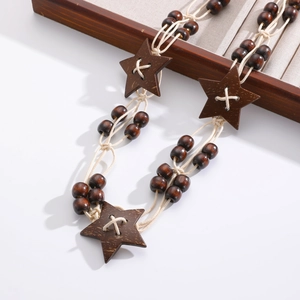Detail of bohemian handmade waist chain with dark brown wood beads and star pendants