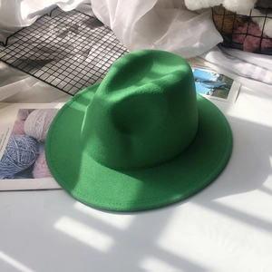 Detail shot of a dark green flat-brim wool fedora hat with a stylish wide brim design