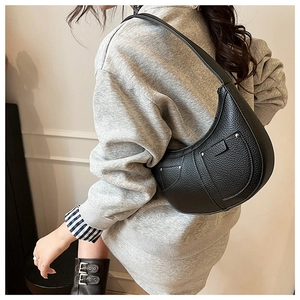 Detail of black crescent shoulder bag with silver rivet studs and荔枝 grain texture