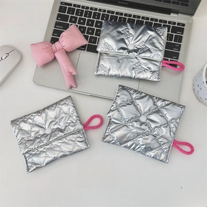 Detail view of silver quilted cosmetic bags with pink loops and metallic snap closure
