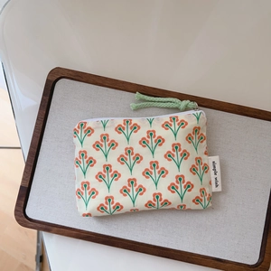 Detail of vintage floral cotton pouch with green cord zipper and simple wish label