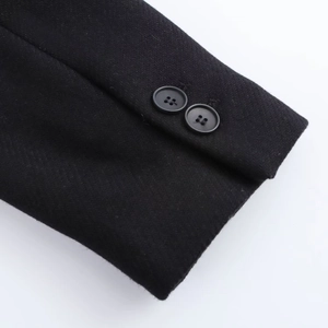 Detail shot of the black wool coat cuff featuring two four-hole buttons and textured fabric