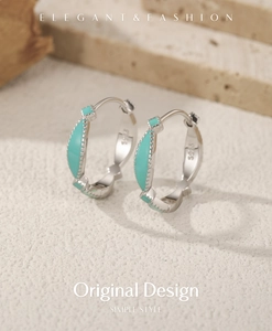 Detailed close-up of S925 silver hoop earrings with mint green enamel on textured background