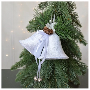 Detail of white velvet Christmas bells with pine cones and berries on green branches