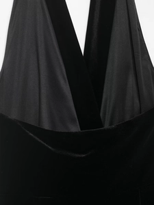 Detail view of black velvet mini dress featuring satin patchwork and elegant fringe trim
