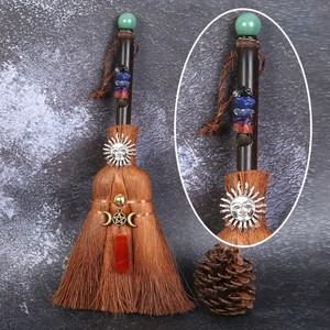 Detail of handcrafted witch broom with natural crystals and pentagram metal charm