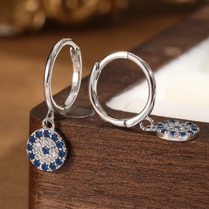 S925 sterling silver hoop earrings featuring blue evil eye charms on a wooden box