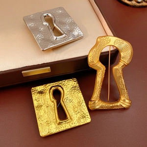 Detailed close-up of vintage square keyhole brooch with gold hammer texture and beadwork