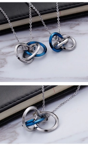 Macro shot of interlocking silver and blue rings with crystals on a steel necklace chain