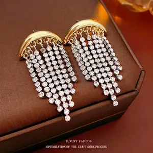 Sparkling crescent moon tassel earrings with golden finish and dangling rhinestones