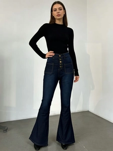 Détail d'un jean évasé à taille haute avec braguette à cinq boutons et coupe ajustée