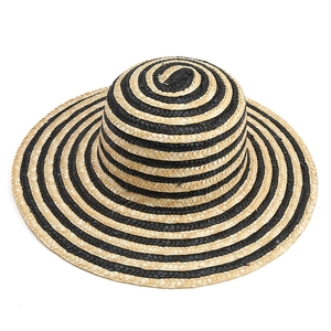 Detail of the woven texture and black and white striped pattern on the sun straw hat