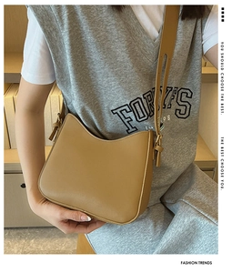 Detail of khaki hobo shoulder bag with wide leather strap and golden hardware accents