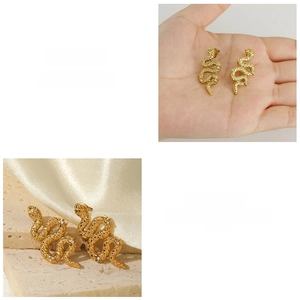 Dettaglio macro di orecchini a serpente in acciaio placcato oro 18K con zirconi