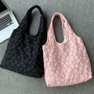 Detail of floral texture embossed tote bags in pink and black for work and school
