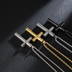 Detailansicht von vier Edelstahl-Kreuzanhängern in Silber, Gold, Schwarz und Antik-Silber