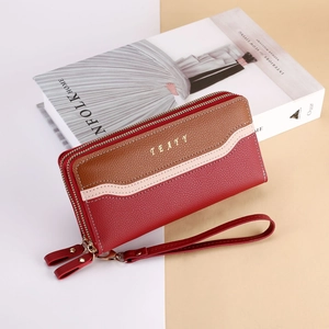 Detail view of tri-color textured leather women's long wallet with double zippers and strap