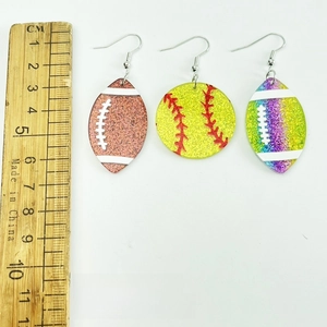 Glitter acrylic sports earrings showing scale with rugby and baseball ball pendants