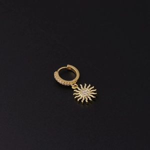 Detail of gold sunburst drop earring with micro-paved cubic zirconia on black background