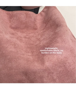 Detailansicht der weichen, matten Wildlederstruktur und des Stoffes der rosa Tasche