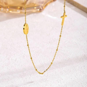 Gold French vintage cross and oval coin pendant necklace with beaded chain on white base