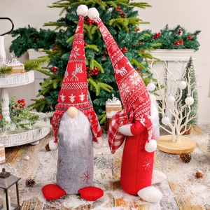 Gnomes de Noël rouge et gris sur neige artificielle avec décors de fête élégants