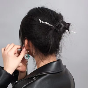 Silver textured hair pin with jade-style pendant and long tassels on black leather model