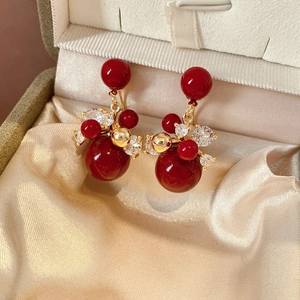 Dettaglio degli orecchini a fiore placcati oro 18K con zircone rosso in scatola regalo