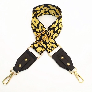 Close-up of leopard print bag strap with brown leather ends and gold metal hardware