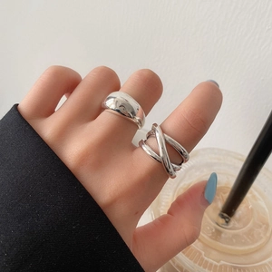 Minimalist silver rings featuring a polished dome design and layered crossover band