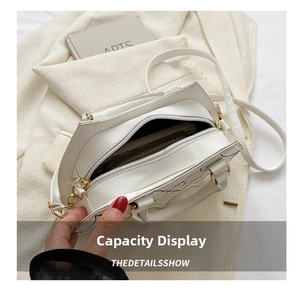 Top view of white leather crossbody bag showing inner capacity for wallets and items