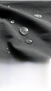 Close-up of waterproof dark grey cotton fabric with water droplets like lotus effect