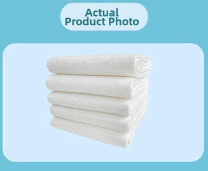 Detail of five white waffle-weave disposable towels stacked against a blue background