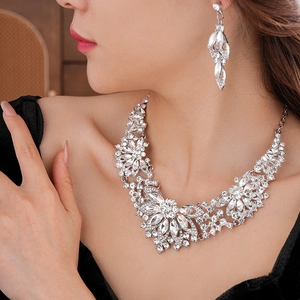Close-up of sparkling floral necklace and earring set with crystals on a model