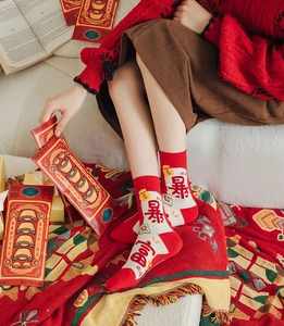 Detail of red cotton Year of the Snake socks with festive embroidery and knit texture
