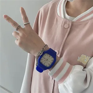 Close-up of blue square silicone sports watch with metal chain bracelet and rings