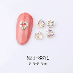 Close-up of 5.5mm golden heart alloy nail art charms with iridescent rhinestones