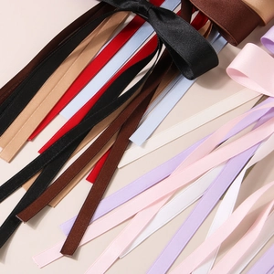 Detailed macro shot of various colored satin ribbons with smooth texture and glossy finish
