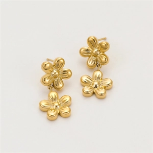 Macro shot of polished gold flower dangle earrings with elegant double floral design
