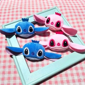 Plush Stitch and Angel cartoon character brooches on a rustic checkered background