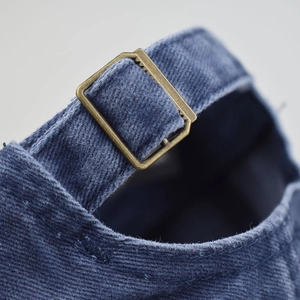 Detail of adjustable antique bronze metal buckle on washed cotton American flag baseball cap