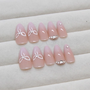 Pink gradient long stiletto press-on nails with white bows and sparkling rhinestones
