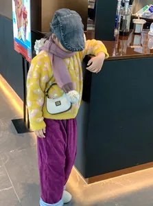 Détail d'un pull léopard, pantalon en velours et mini sac argenté pour look hiver enfant