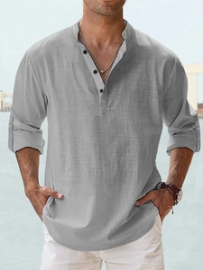 Detail of grey linen shirt texture and button collar on model with seaside background