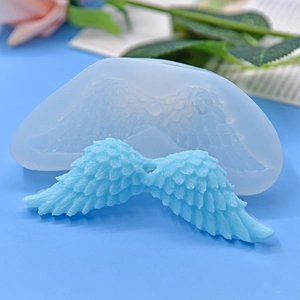 Angel wing silicone mold with detailed feather texture and finished light blue clay wing